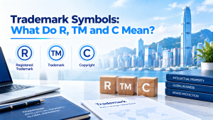 Infographic titled Trademark Symbols: What Do R, TM and C Mean? with Hong Kong skyline background, wooden blocks marked R, TM, C, laptop and intellectual property books on table, explaining registered trademark, trademark and copyright symbols.